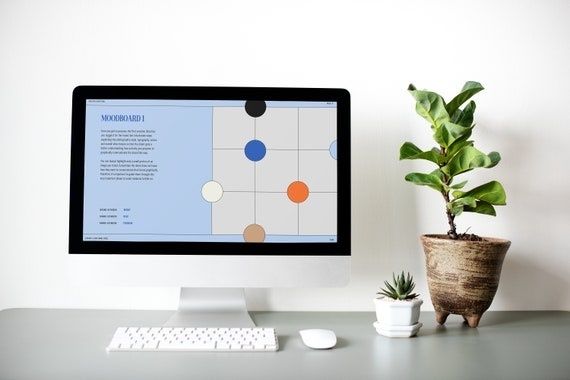 Desktop monitor displaying a structured branding moodboard beside houseplants