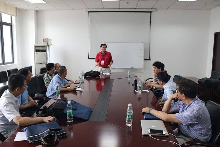 Team meeting around a conference table with a presenter and whiteboard